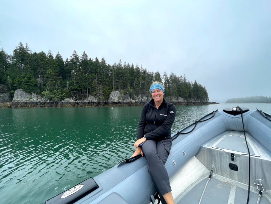 A Maritime Gal smiling in a skiff on calm northern waters